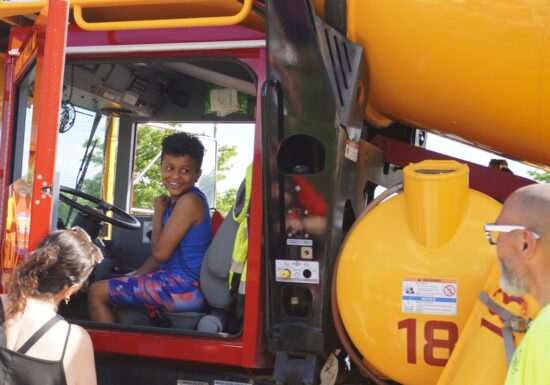 A picture of a truck and attendee at a community touch-a-truck event.