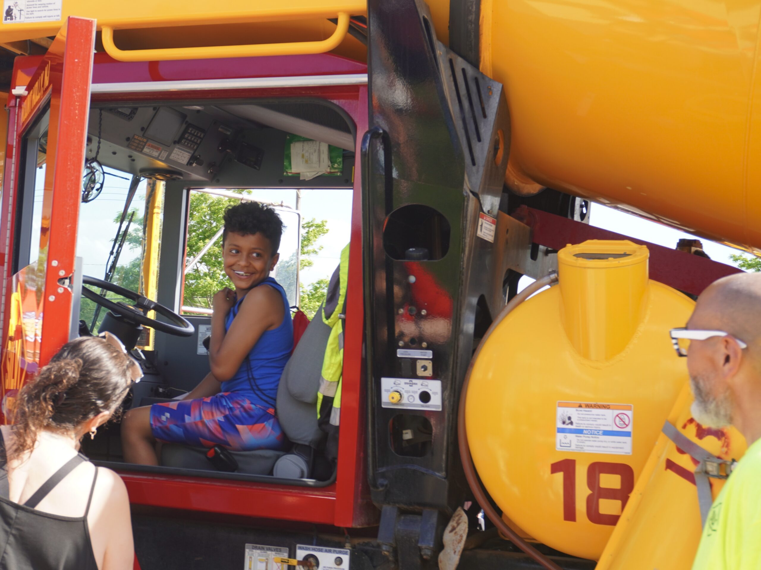 A picture of a truck and attendee at a community touch-a-truck event.
